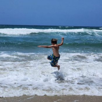 Child jumping into the ocean waves